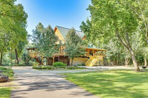 A lodge with a wooden exterior, a covered porch, and a staircase leading to a deck. - Creek Access, Games: Family-Friendly Royal Retreat (Royal)