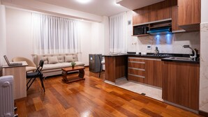 Una cocina moderna con armarios de madera, microondas integrado y un lavabo.