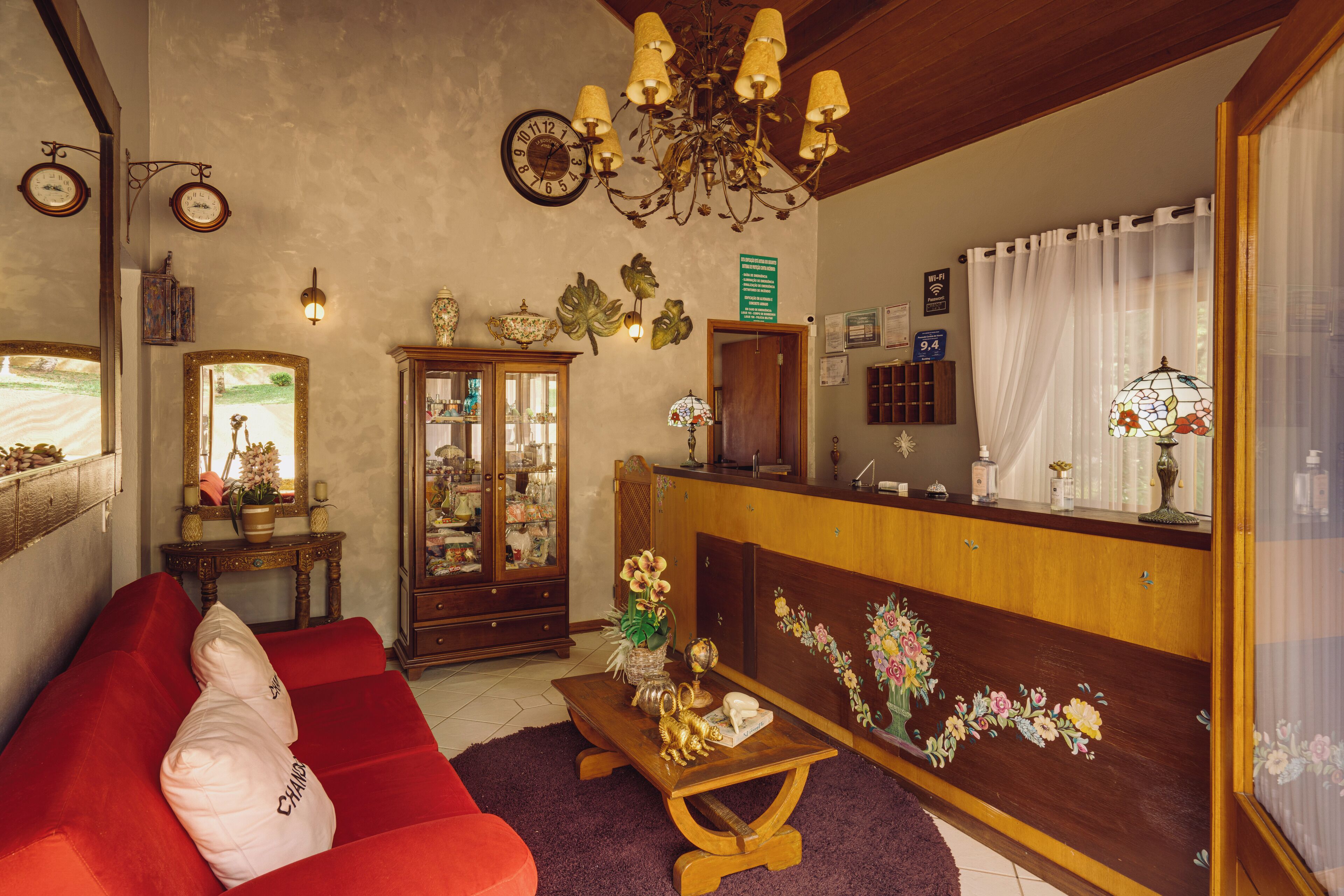 Uma sala de estar aconchegante com um sofá vermelho, mesa de centro de madeira e um candelabro.
