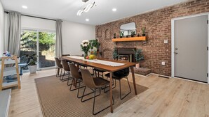Un coin repas avec un mur en briques, une cheminée et une grande fenêtre.