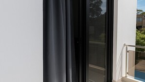 Eine moderne Schiebeglastür mit schwarzem Rahmen und einer weißen Außenwand.