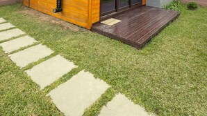 A modern wooden cabin with a metal roof, a fire extinguisher, and a paved entrance. - Chalé Cabernet - Vila Chamonix (Urubici)