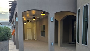 En byggnad med en överbyggd gång, flera dörrar och takfläktar.