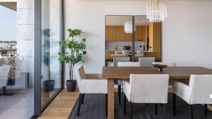 Un comedor moderno con una gran mesa de madera, seis sillas y una planta en maceta.