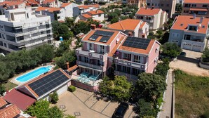 Un quartier résidentiel comprenant plusieurs immeubles, une piscine et des panneaux solaires installés sur les toits.