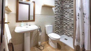 Un baño con lavamanos, inodoro y ducha.