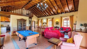A spacious living area with a pool table, red sofas, and a billiards table. - Cortijo Hacienda Nueva Lora del Río by Ruralidays (Sevilla)