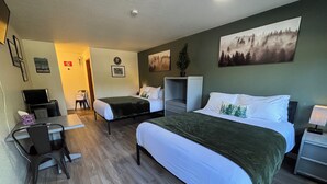 A hotel room with two beds, a desk, a chair, a TV, and a small table. - Red Bell Inn (Leavenworth)