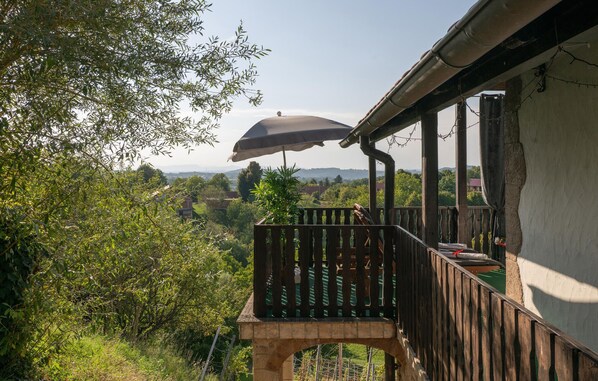 A wooden deck with a view of a lush landscape.