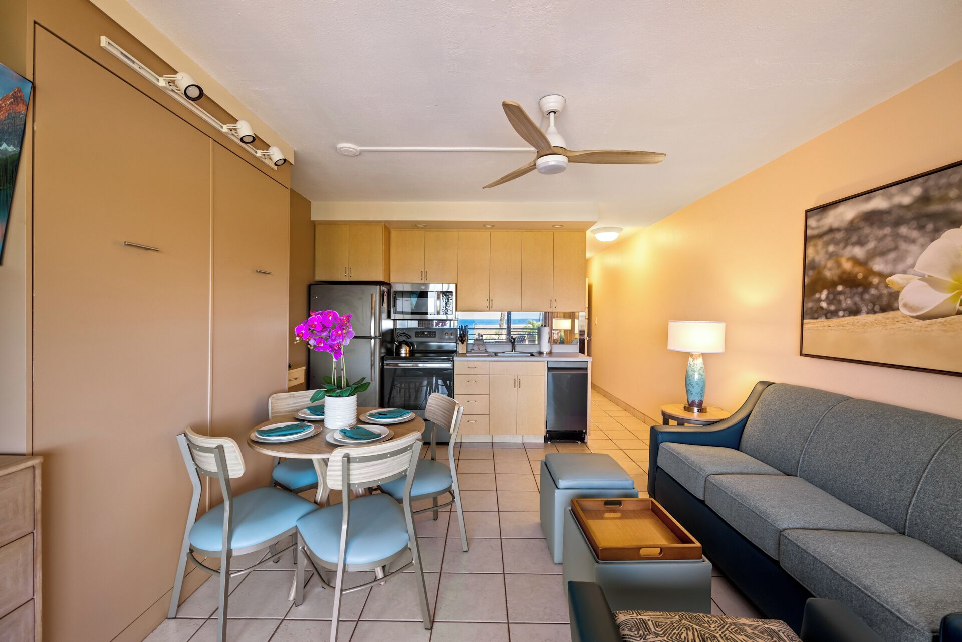 Un espacio habitable compacto con kitchenette, comedor y zona de estar.