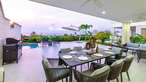 An outdoor dining area with a view of the ocean, a grill, and lounge seating. - Villa Ferraj - by Zenbreak (Westmoreland)