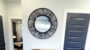 A dining area with a wooden table, two black chairs, a black metal stand, and a blue towel. - Walkable 1-Bed in East Nash, 2mi to DT, 5 Pts (Nashville)