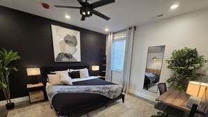 A modern bedroom with a bed, bedside tables, a desk, and a chair. - Walkable 1-Bed in East Nash, 2mi to DT, 5 Pts (Nashville)