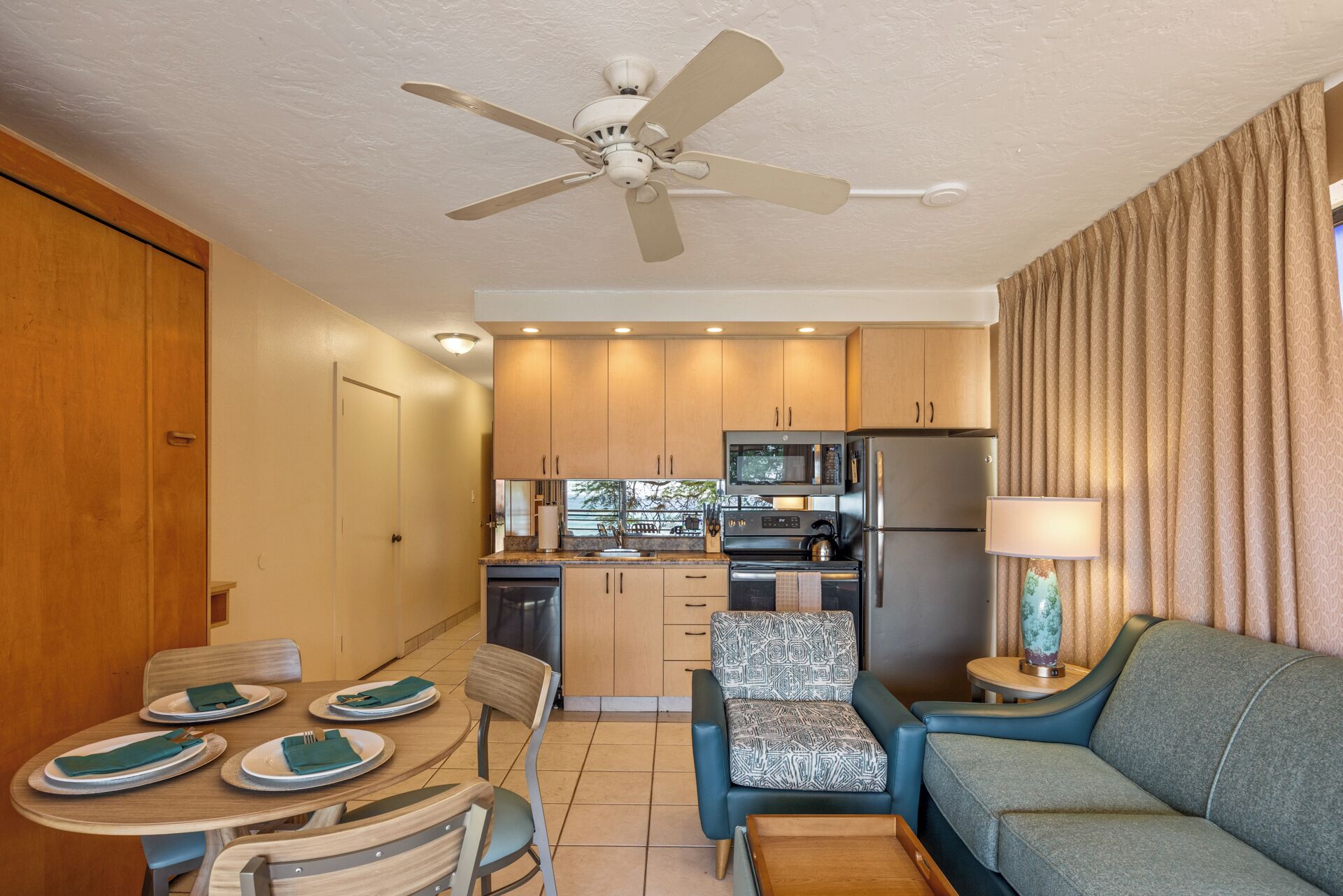 A compact living space with a kitchenette, dining area, and seating.