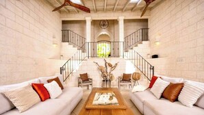 Ein geräumiger Wohnbereich mit zwei Sofas, einem Couchtisch und einer Treppe zu einer oberen Ebene.