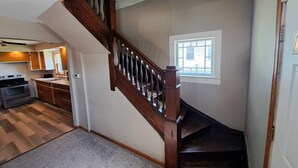 A staircase with wooden balusters leading to a landing. - Whole Home by Heritage Trail, quiet street, outdoor games (Dubuque)