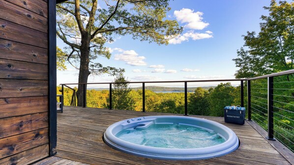 A wooden deck with a hot tub, a view of a forest, and a clear sky. - Modern Catskills Escape w/ Open Living, Steam Shower, & Hot Tub w/ Mountain Views, Minutes From Woodstock & Trails Suncliff Vista (Glenford)