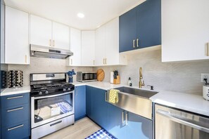 A modern kitchen with a stove, oven, microwave, and sink. - Cheerful Modern 4 Beds | Bright & Easy  to BART (San Leandro)