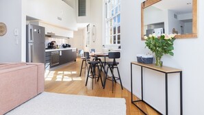 Une cuisine moderne équipée d’un réfrigérateur, d’une cuisinière et d’un coin repas avec des chaises et une table.