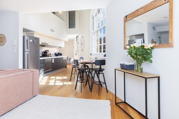 Eine moderne Küche mit Kühlschrank, Herd und Essbereich mit Stühlen und Tisch.