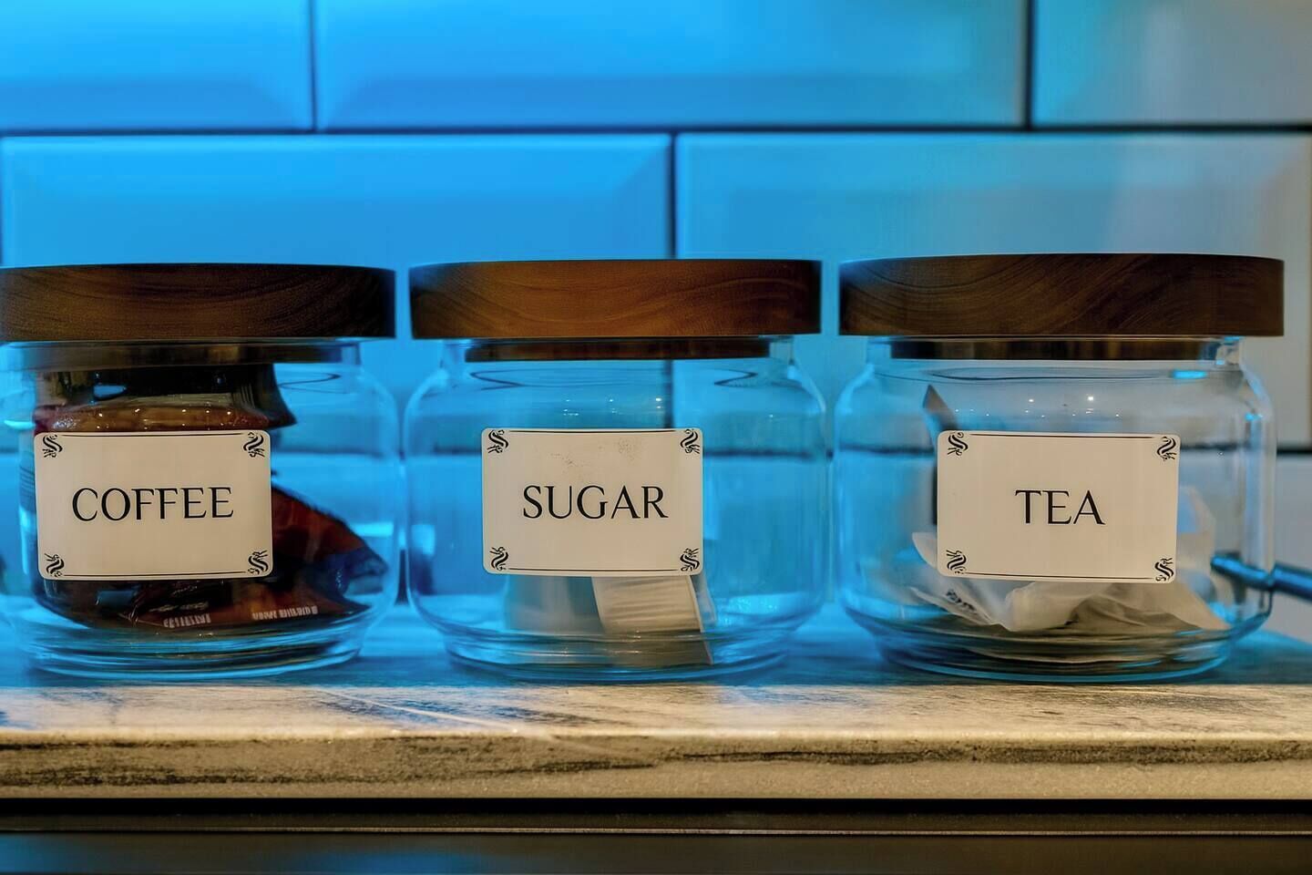Three glass jars with labels on a kitchen counter.