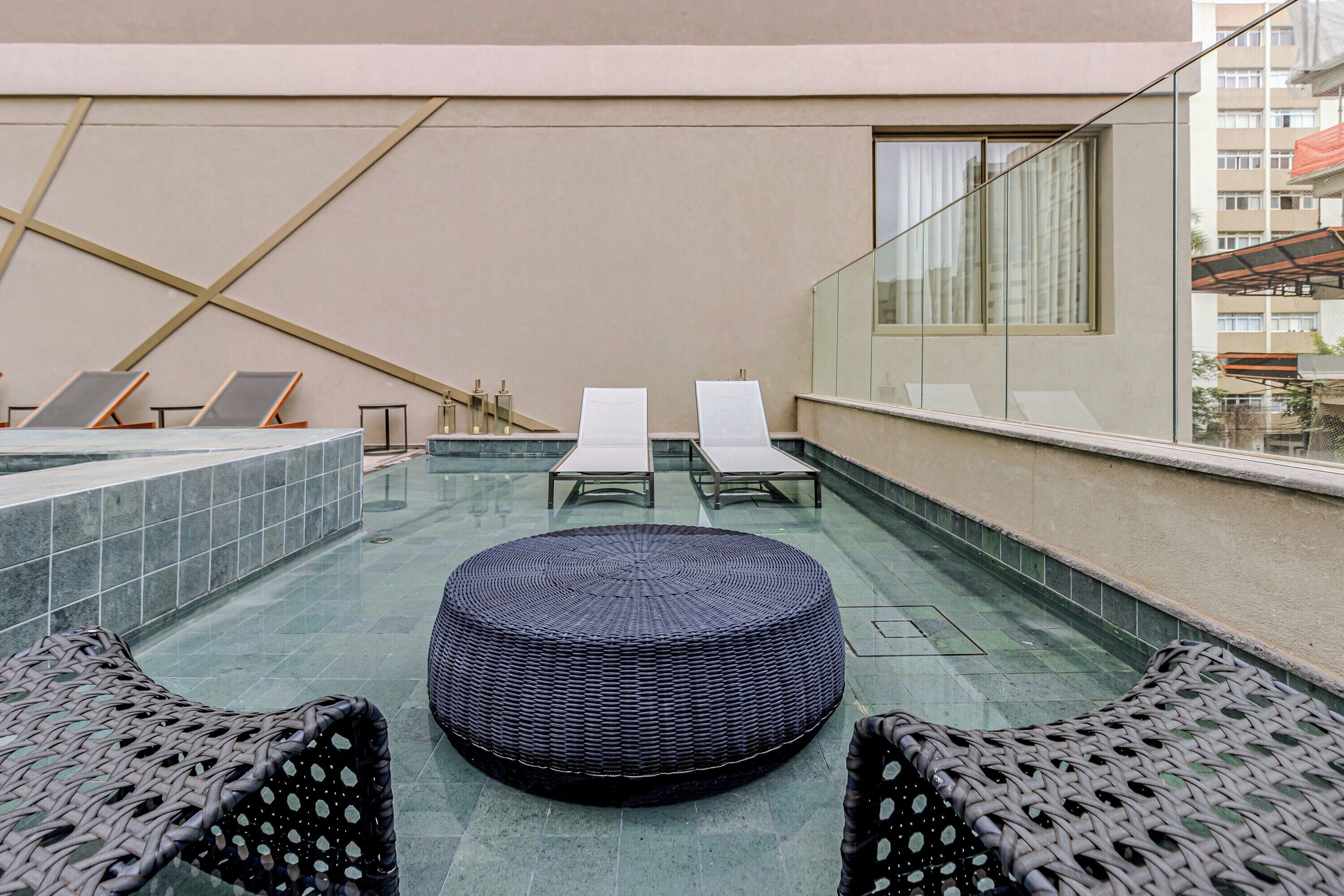 Una piscina al aire libre, sillones reclinables de piscina