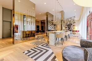 A modern hotel lobby with a bar area, seating, and a patterned rug. - Charlie For You Perdizes (São Paulo)
