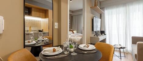 A dining area with a round table, chairs, and a mirror.