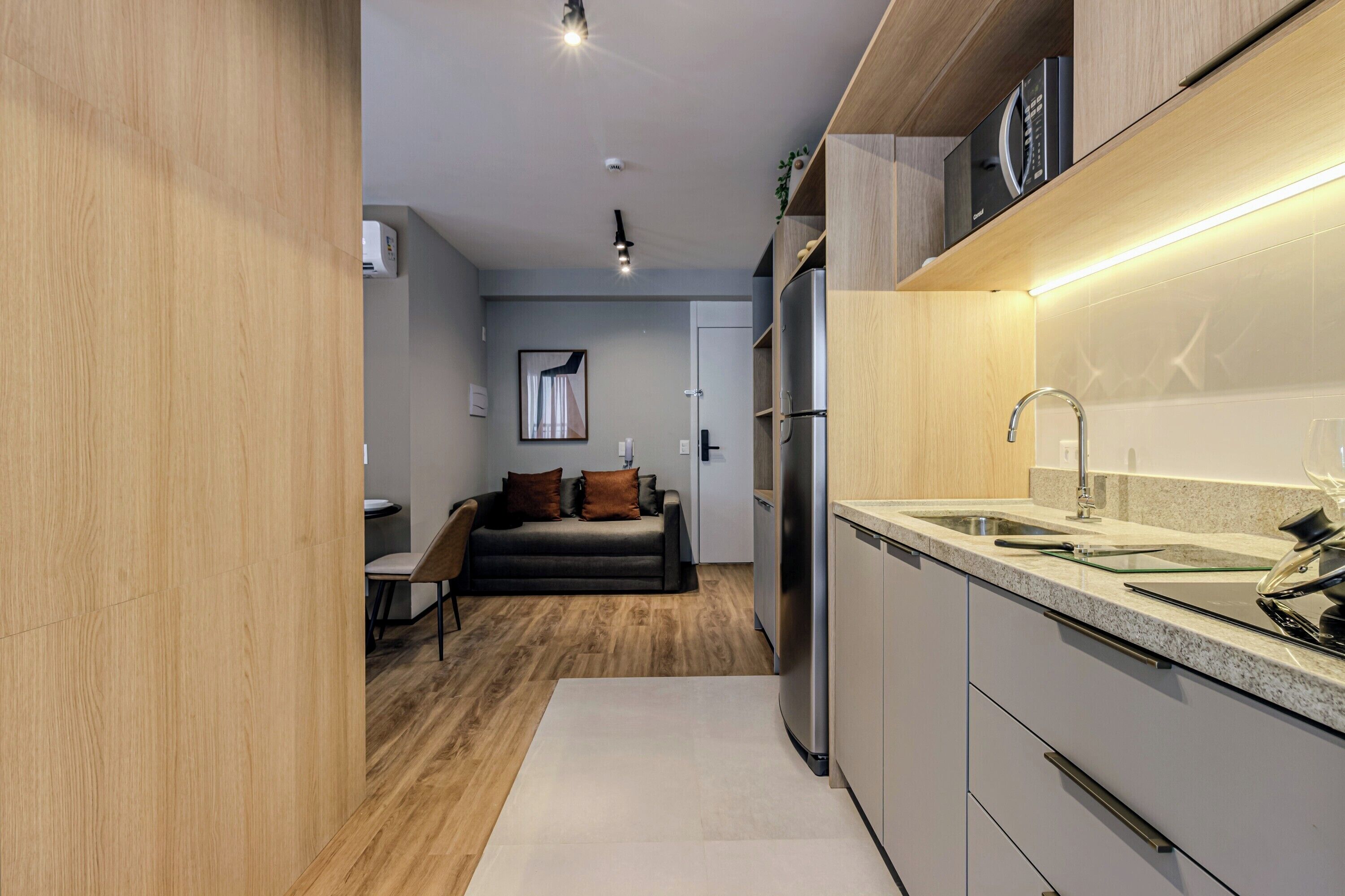 A modern kitchen with a stainless steel refrigerator, a granite countertop, and a built-in sink.