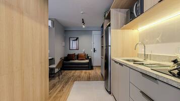 A modern kitchen with a stainless steel refrigerator, a granite countertop, and a built-in sink.