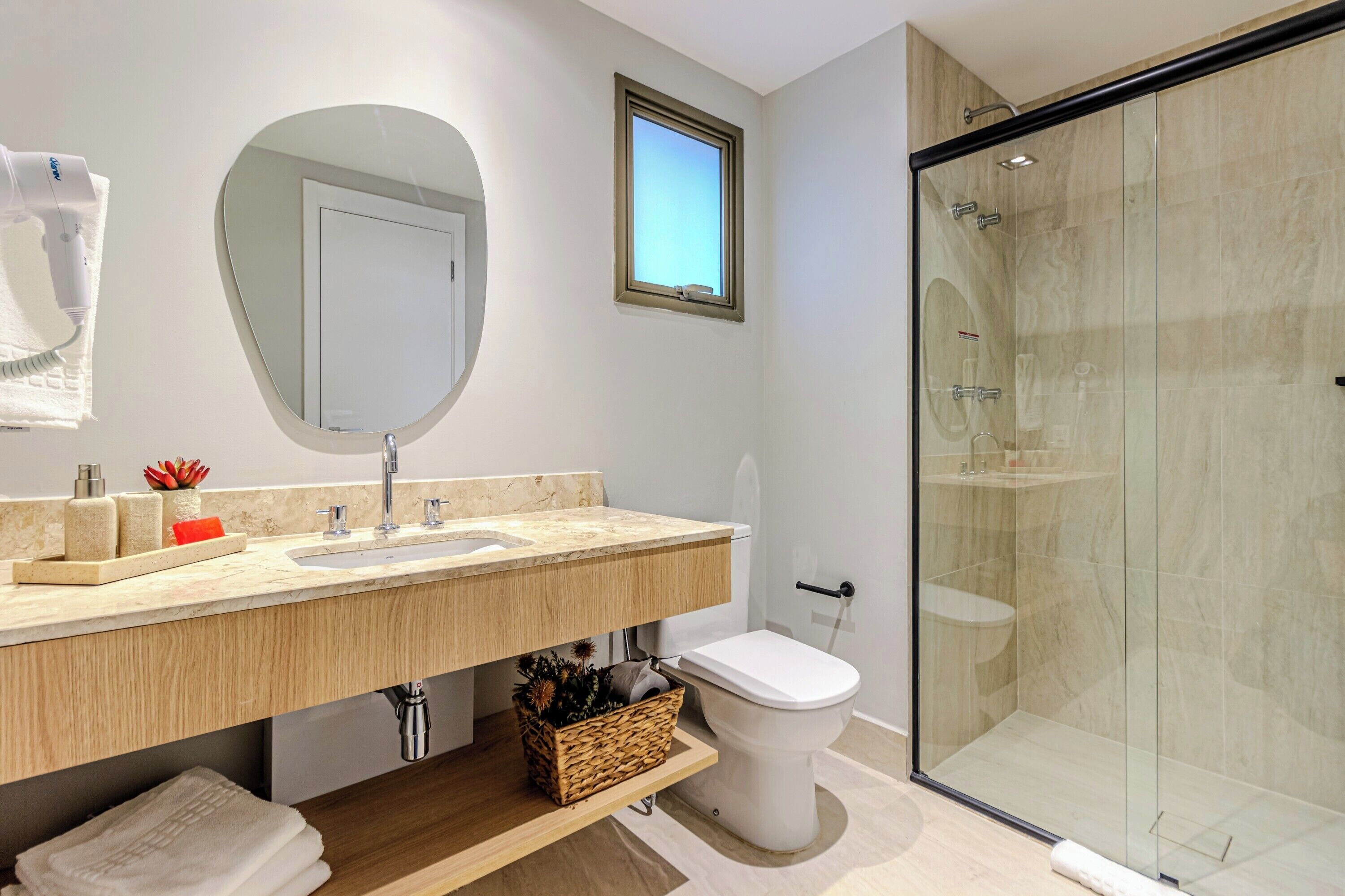 Ein modernes Badezimmer mit einem Holzkosmetikschrank, einer Duschkabine aus Glas und einer Toilette.