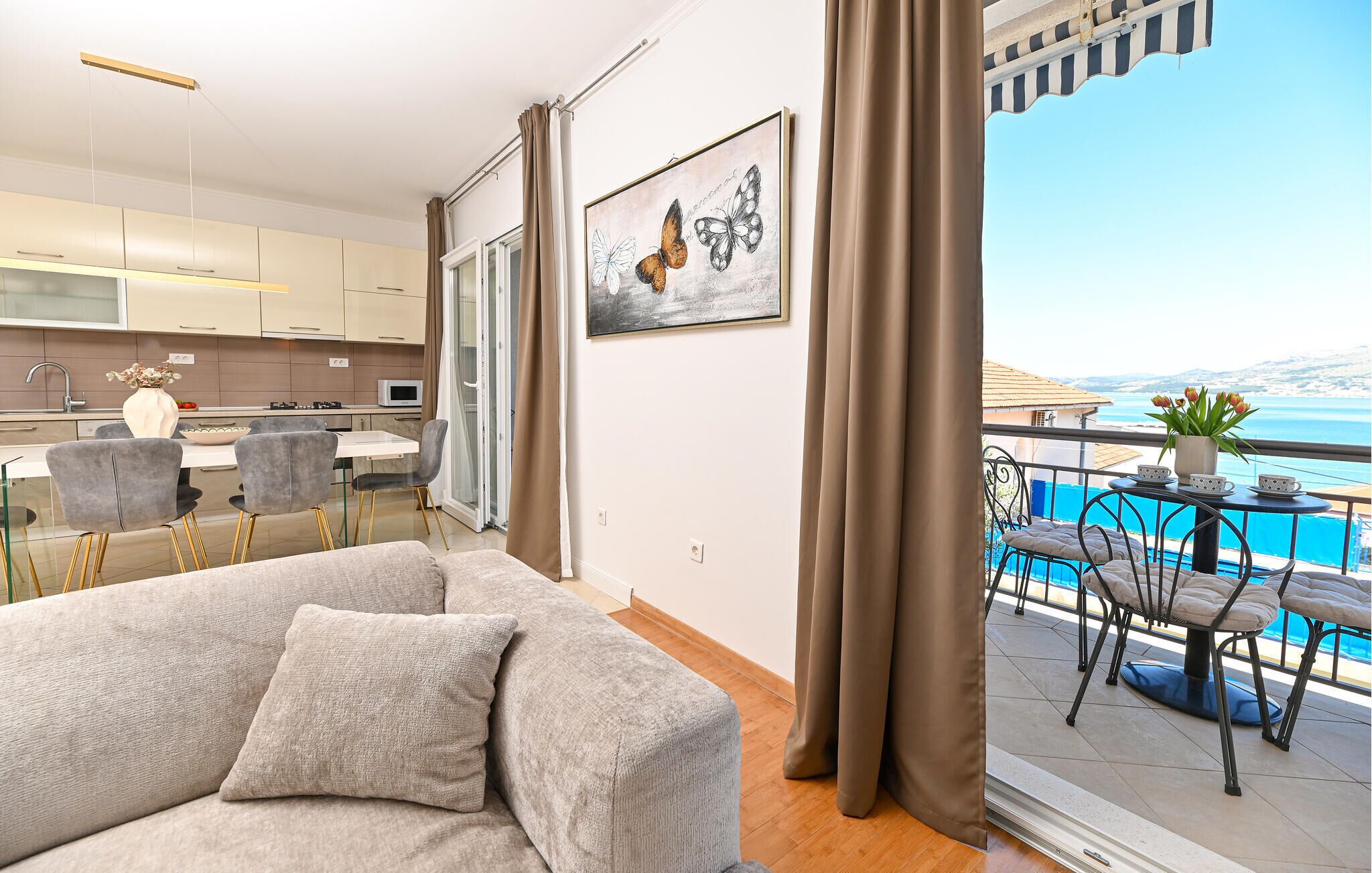 Un appartamento moderno con un balcone che si affaccia su un panorama suggestivo, una zona pranzo e una cucina.