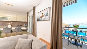 Un appartement moderne doté d’un balcon offrant une vue panoramique, d’un coin repas et d’une cuisine.