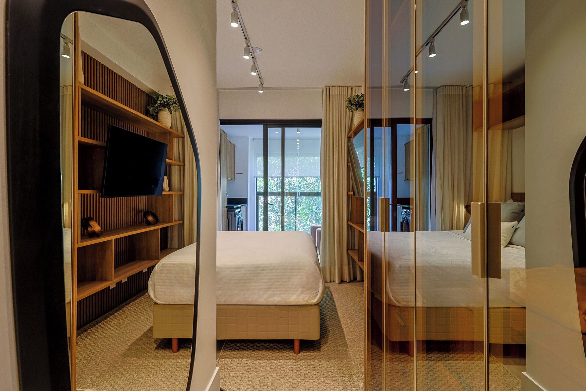 Una habitación de hotel moderna con una cama grande, un televisor y un armario.