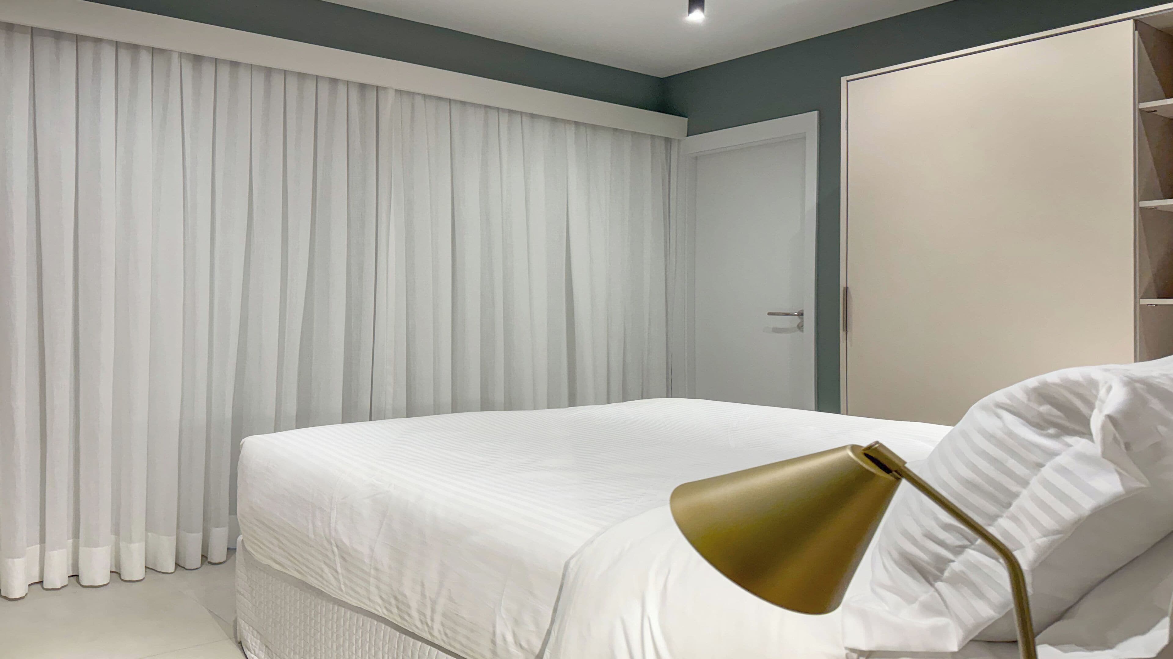 Ein Schlafzimmer mit einem Bett, einem Kleiderschrank und einem Vorhang.