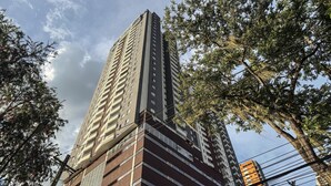 A tall, multi-story building with a modern architectural design, featuring a mix of glass and brick facades. - Mountain View, Pool & Gym (2506) (Sabaneta)