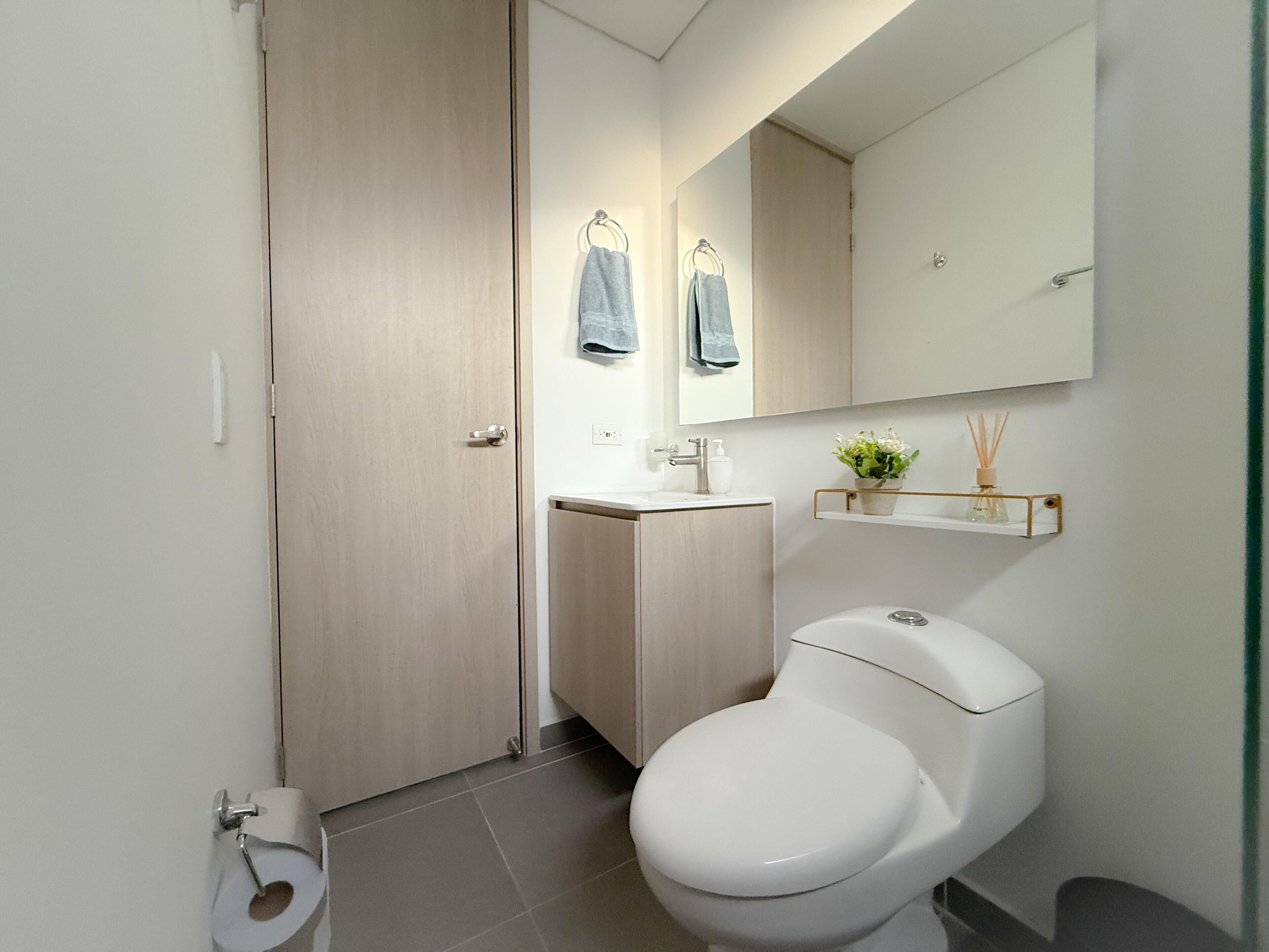 Une salle de bain moderne avec des toilettes, un lavabo et un miroir.