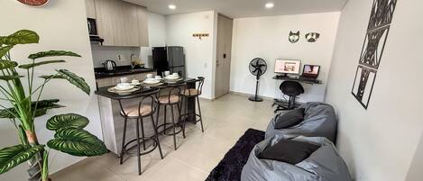 A modern living space with a kitchen, dining area, and seating area.