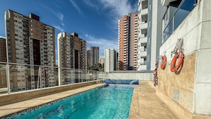 A rooftop swimming pool with clear blue water, surrounded by high-rise buildings and a tiled deck. - Mountain View, Pool & Gym (2506) (Sabaneta)