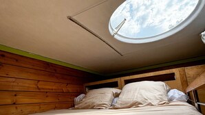 Un lit superposé avec une lucarne dans une chambre de cabane en bois.