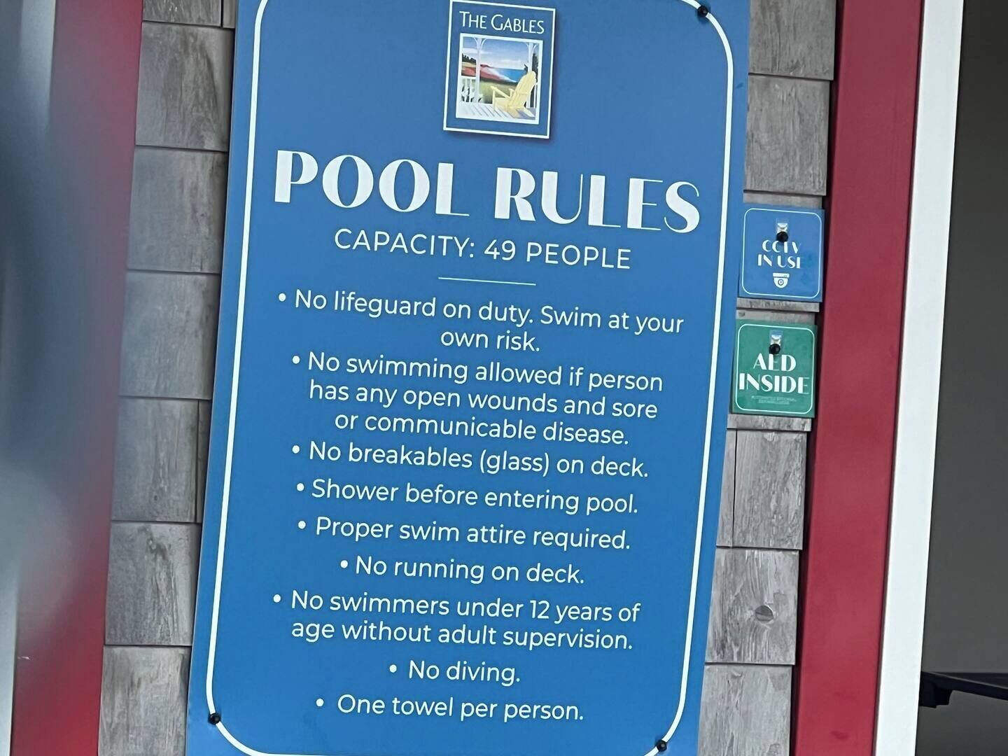 A pool rules sign with a capacity of 49 people.