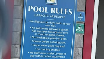 A pool rules sign with a capacity of 49 people.