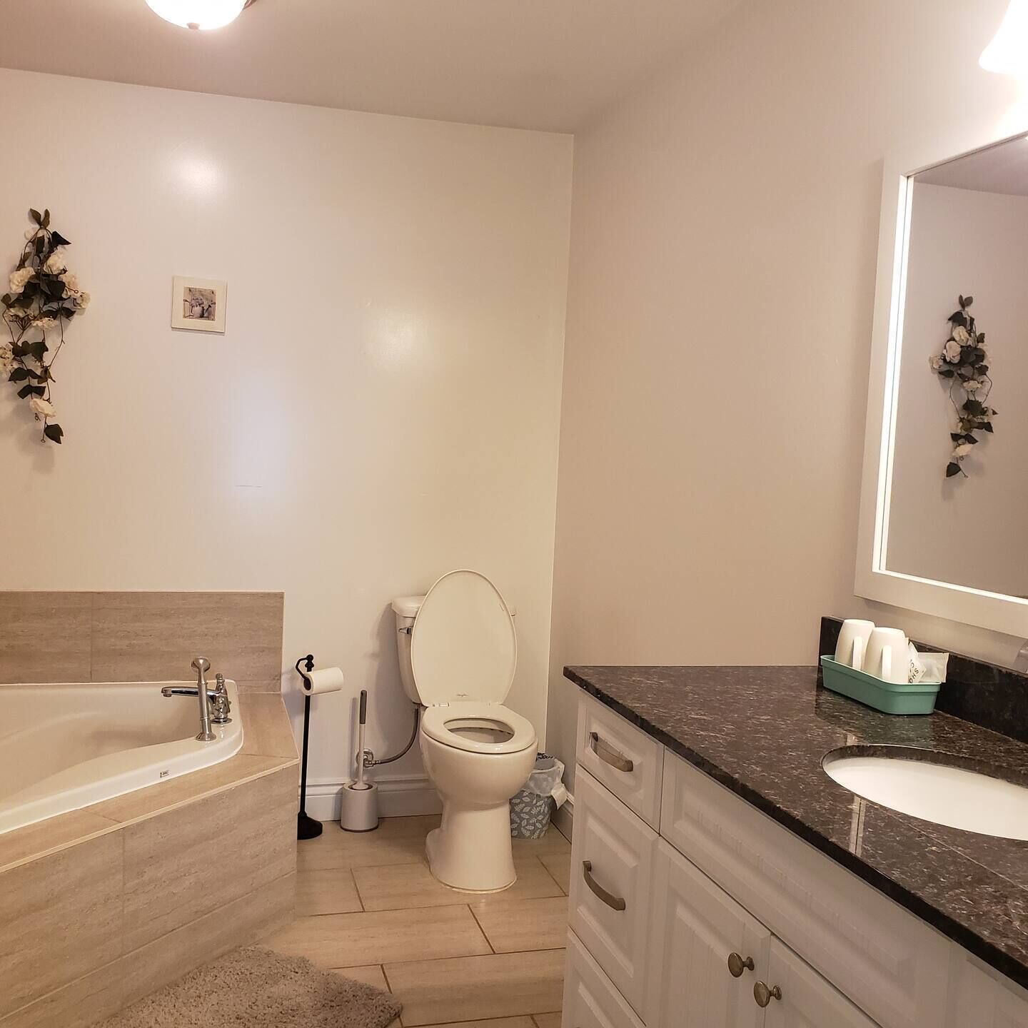 A modern bathroom with a bathtub, toilet, and sink.