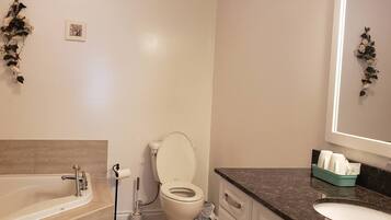 A modern bathroom with a bathtub, toilet, and sink.