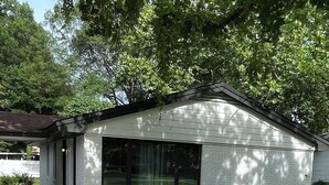 A single-story house with a large window, a garage, and a covered porch.