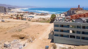 A coastal area with a sandy beach, a few buildings, and a large body of water. - Pico del Punto • New Penthouse with Panoramic Views, Surf Access & Rooftop Deck (Los Cerritos)