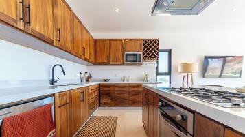 Una cucina moderna con mobili in legno, un forno a microonde, un piano cottura a gas e un'ampia finestra.
