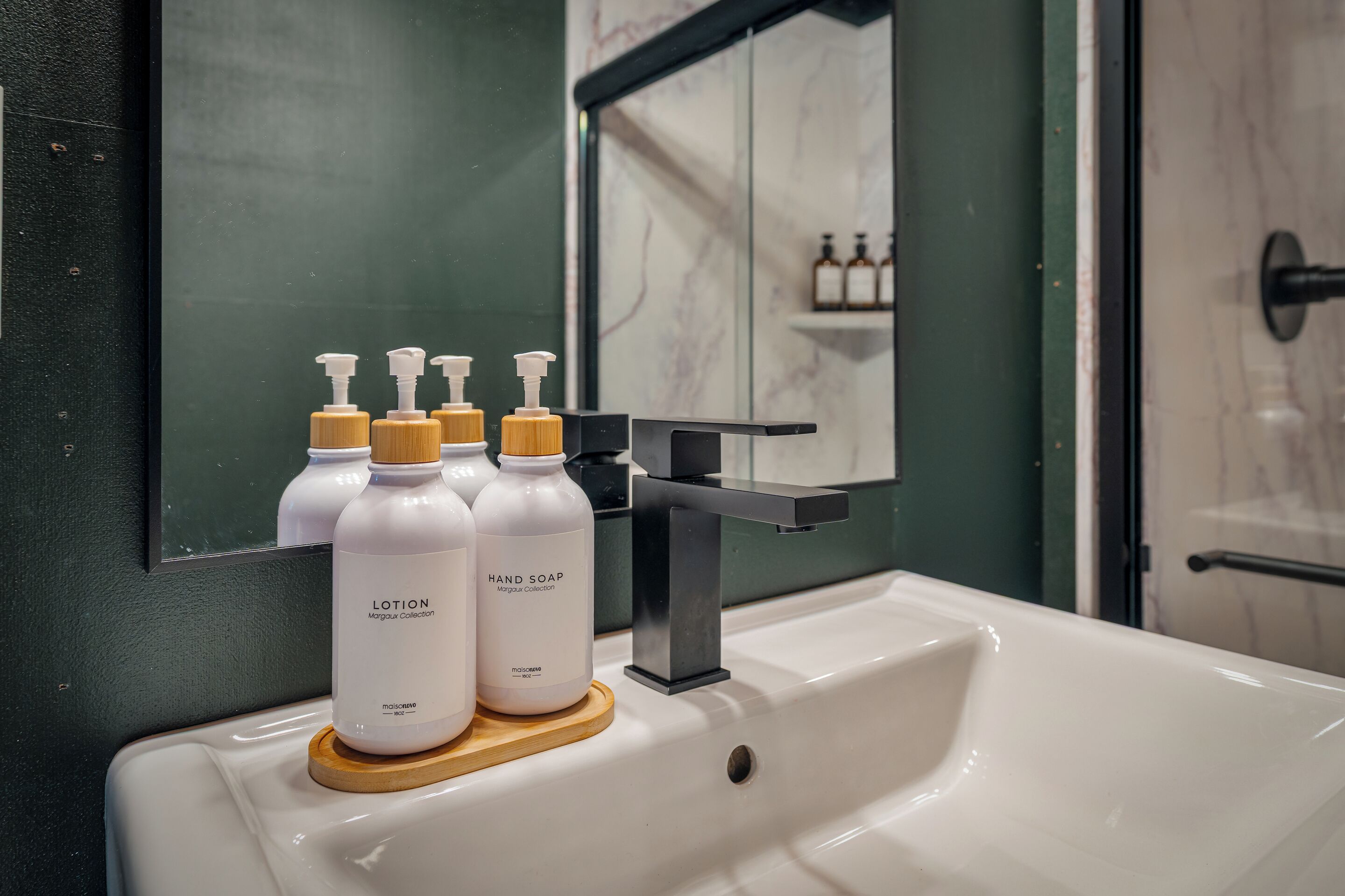 A bathroom sink with hand soap and lotion bottles.