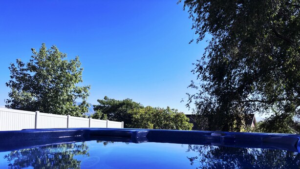 A clear blue sky with a white fence and trees in the background. - Feel cozy and at home! Perfect Location For Exploring! (Provo)