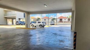 A parking garage with multiple levels and a view of the surrounding buildings. - Comfortable 1BR apt, swimming pool (Playa Juan Dolio)